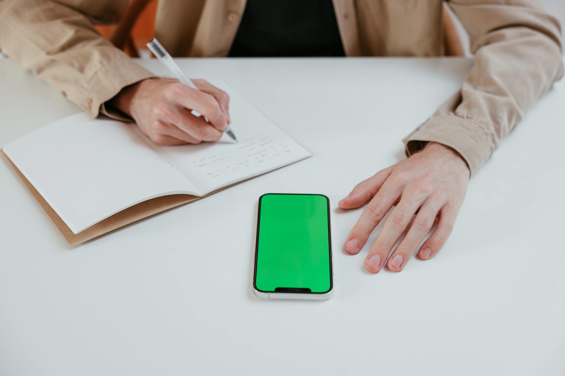 Sổ tay ghi ngân sách chơi xổ số bên cạnh điện thoại và máy tính